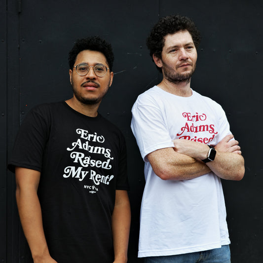 two men wearing black and white "eric adams raised my rent" t-shirts